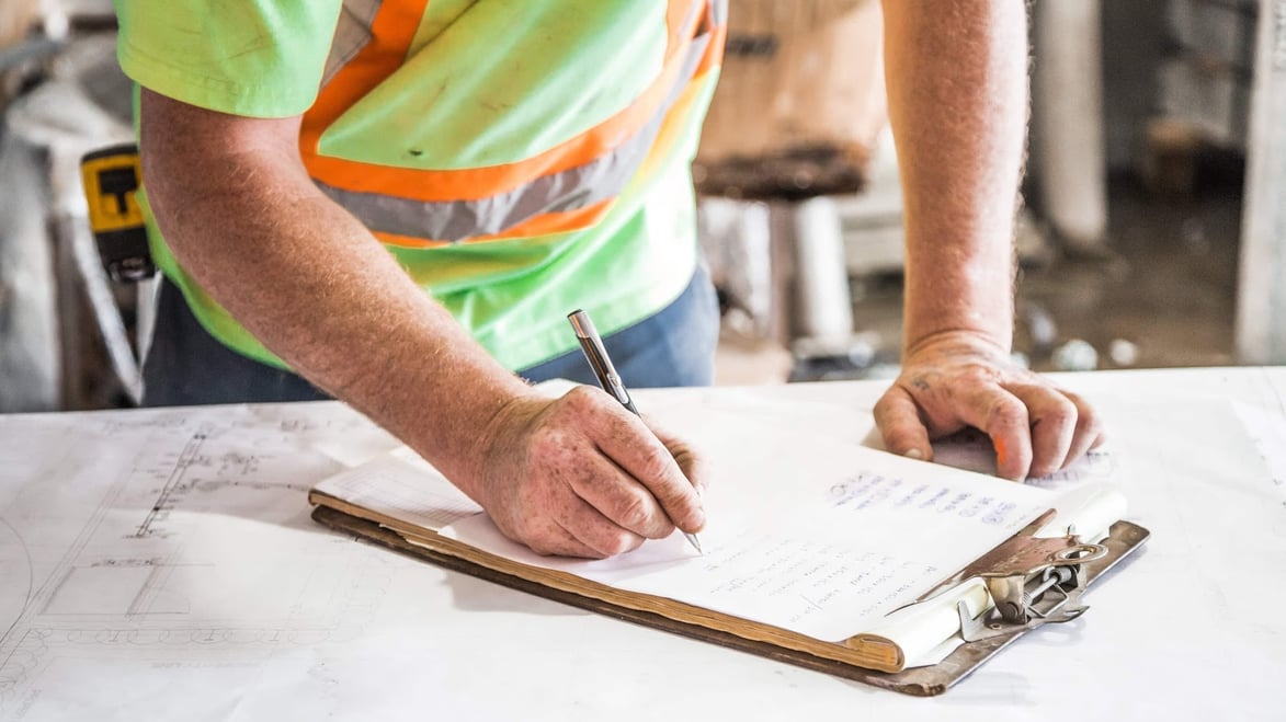 construction worker looking at blueprints