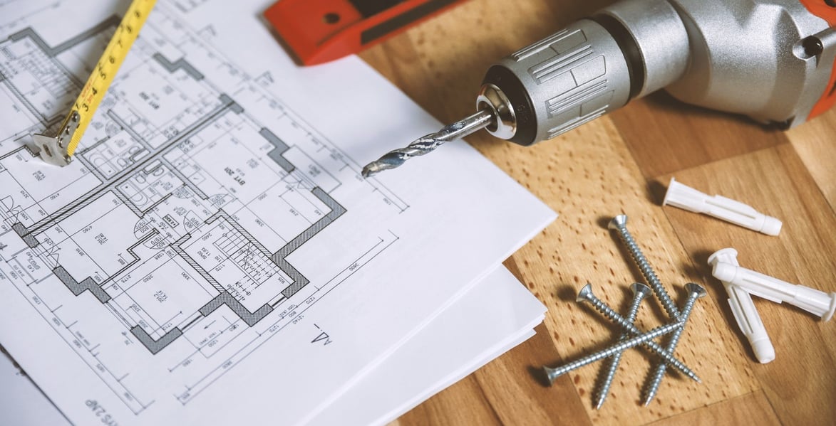 drill and spirit level on floor with floor plan chart