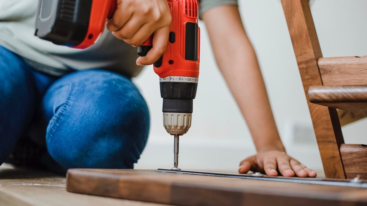 using a drill on a wooden board